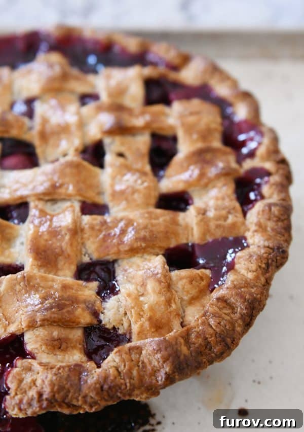 A beautifully baked cherry pie, golden brown with a perfectly set lattice crust, cooling after baking.