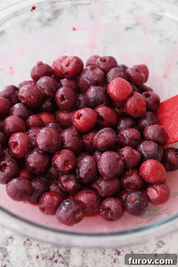 A glass bowl filled with vibrant homemade cherry pie filling, showcasing plump, juicy cherries ready for baking.