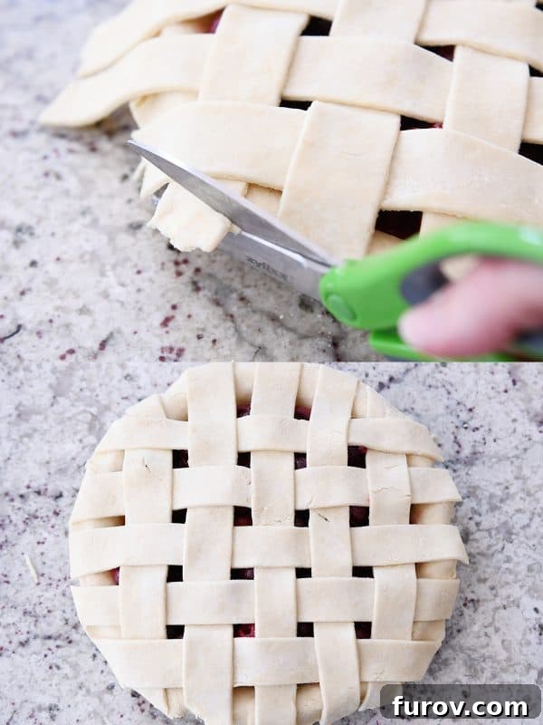 Using kitchen scissors to trim the edges of the cherry pie crust, ensuring a neat and even finish.