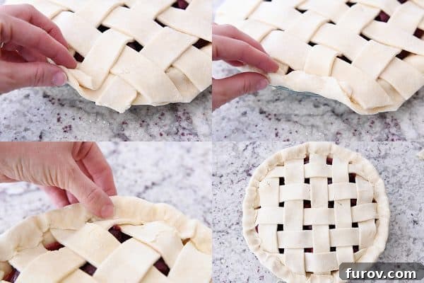 Folding the bottom edge of the cherry pie crust upwards and over the lattice strips, sealing the edges together.