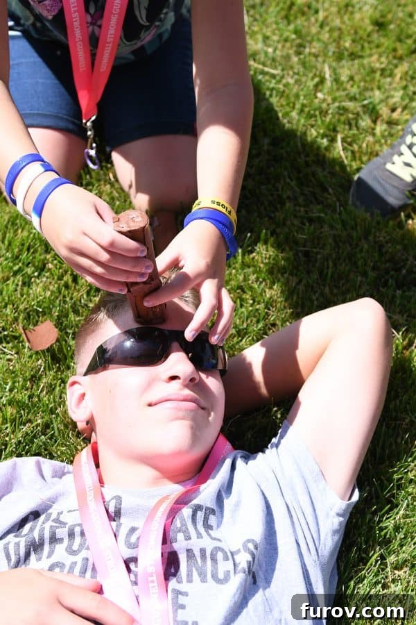 A child participating in a family Olympic game, balancing a snack on their forehead.