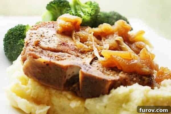 Sweet and Savory Pork Chops with Caramelized Apples and Onions 2 Cooked bone-in pork chop on top of mashed potatoes.