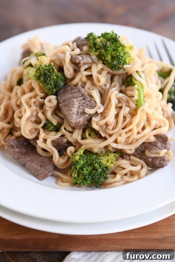Effortless Beef and Broccoli Ramen Skillet 5 White plate piled high with easy one pot beef and broccoli ramen noodles. A hearty serving of one-pot beef and broccoli ramen.