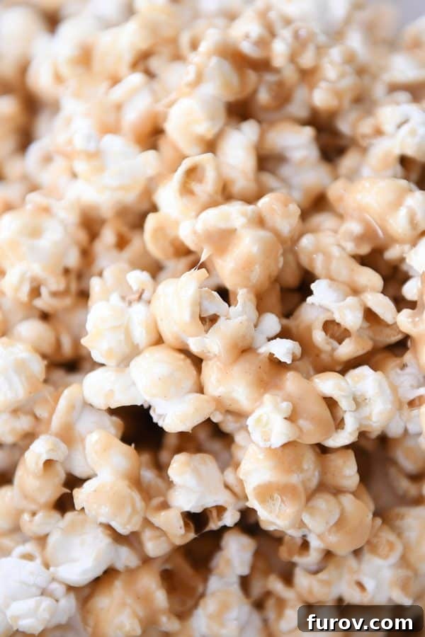 Gooey Peanut Butter Popcorn 4 A mouthwatering close-up of soft and chewy peanut butter caramel popcorn, showing the glossy, rich coating on each kernel.