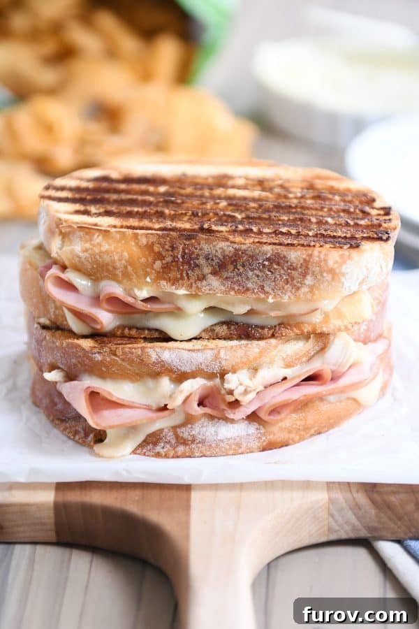 Two Chicken Cordon Bleu Panini sandwiches, artfully stacked, showcasing their golden crust and enticing filling.