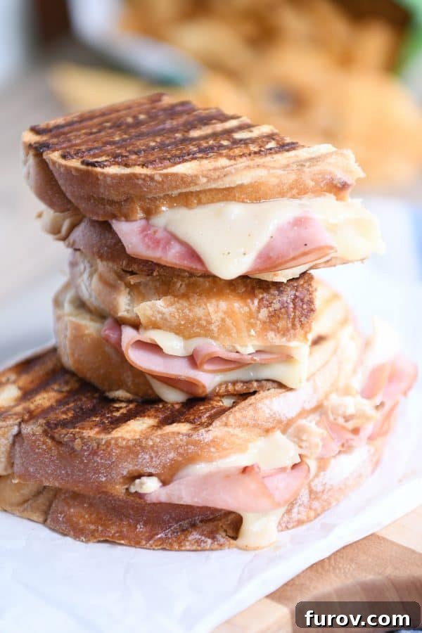 Three perfectly stacked Chicken Cordon Bleu Panini sandwiches, ready to be enjoyed.