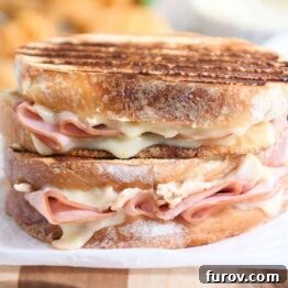 Two chicken cordon bleu panini sandwiches stacked on top of each other.