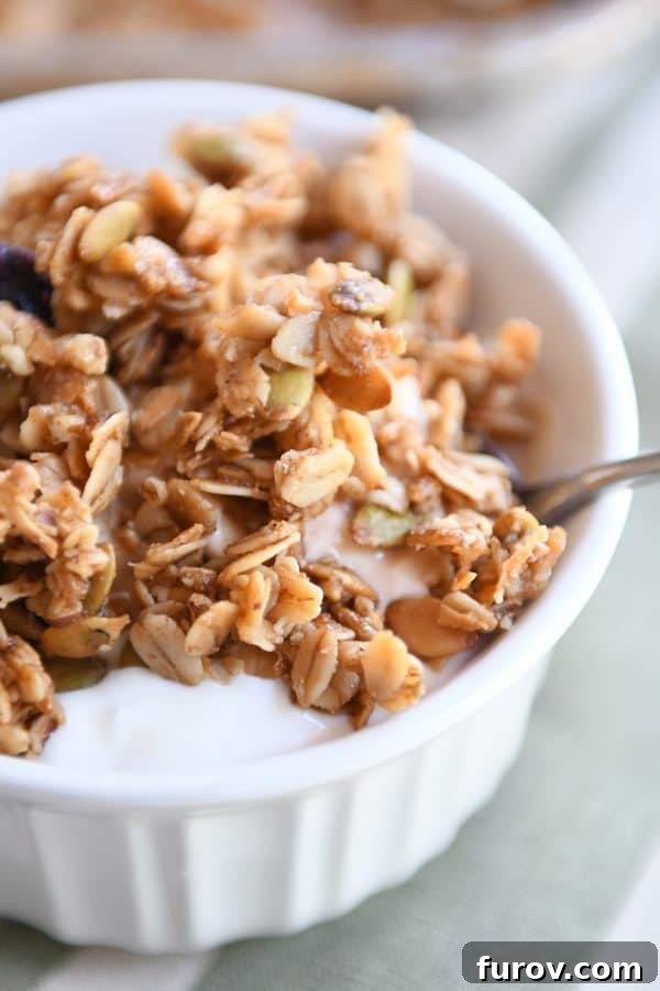 White bowl with yogurt and brown butter pecan granola.
