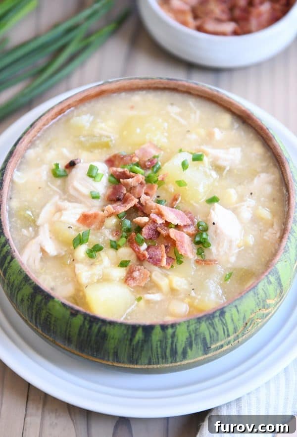 A green bowl brimming with creamy Pressure Cooker Chicken Corn Chowder, generously topped with crispy bacon. This hearty, dairy-free soup is perfect for family meals.