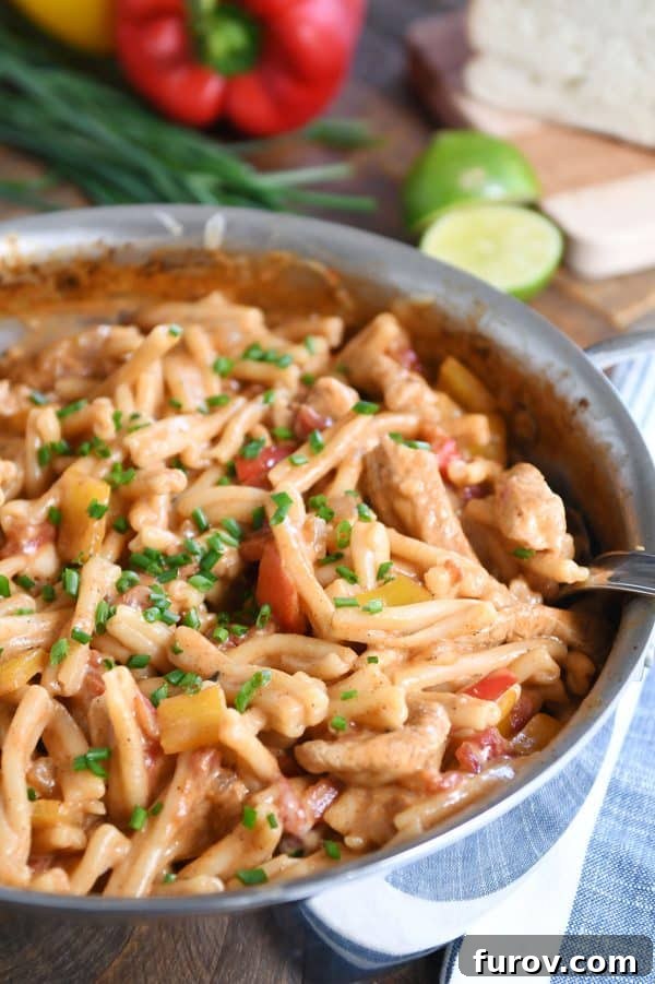 Fiesta Skillet Chicken Fajita Pasta 11 Shallow pan filled with skillet chicken fajita pasta, garnished with fresh chives on top.