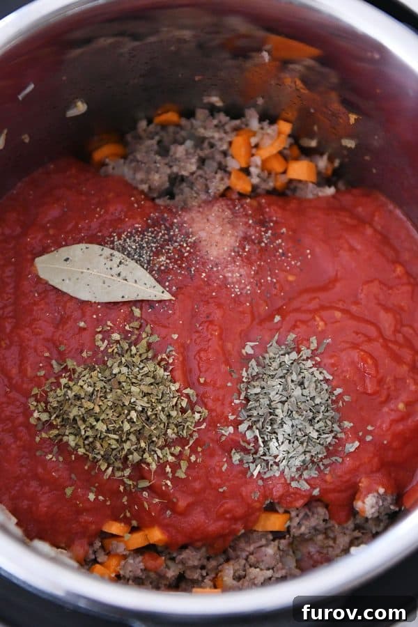 Homemade Lasagna Soup Pressure Cooker or Stovetop 4 Close-up shot of crushed tomatoes and spices being added to the pressure cooker for lasagna soup, highlighting the fresh ingredients.