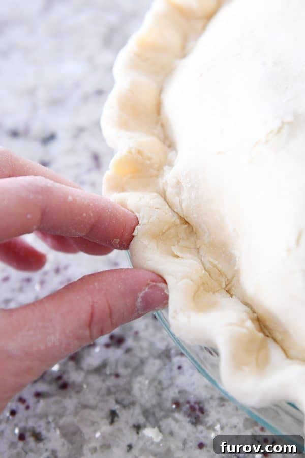 My Favorite Thanksgiving Apple Cranberry Pie 11 Crimping edges of double pie crust.