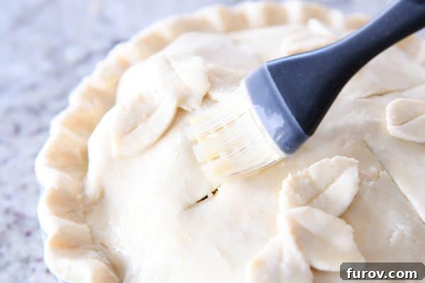 My Favorite Thanksgiving Apple Cranberry Pie 13 Brushing egg wash on top of apple cranberry pie.