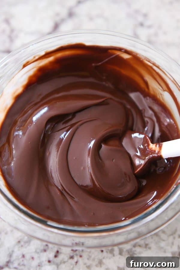Homemade Dulce de Leche Caramel Shortbread Bars 13 Glass bowl filled with smooth, glossy chocolate ganache, ready to be poured.
