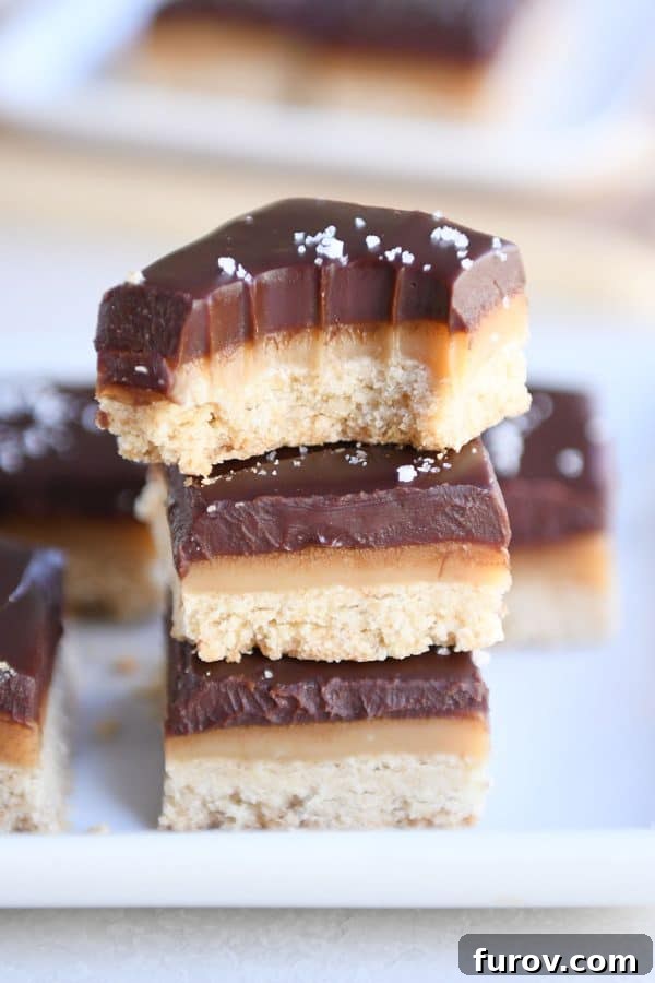 Homemade Dulce de Leche Caramel Shortbread Bars 17 Three homemade grown up Twix bars stacked on each other with a bite taken out of the top one.