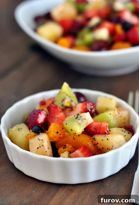 Zesty Honey Lime Fruit Medley 9 A charming white ramekin holding a small, artfully arranged portion of honey lime fruit salad, ready to be enjoyed as a delightful individual serving or a light dessert.