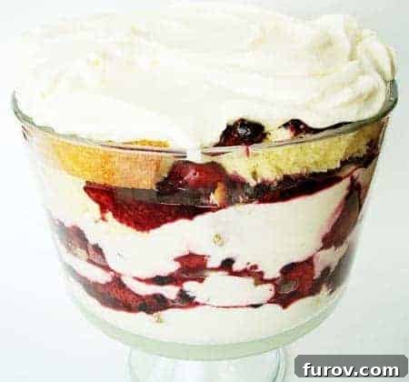 Zesty Berry Trifle 3 Close-up view of the layered Lemon Berry Trifle in a clear glass dish, showing the intricate arrangement of pound cake, berry mixture, and lemon cream.