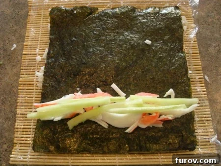 Slices of fresh cucumber laid over the imitation crab meat on the nori, adding a fresh crunch to the filling.