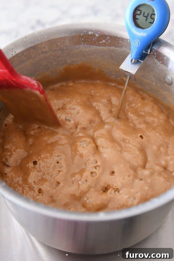 Homemade caramels cooking to the ideal temperature of 245 degrees, indicating perfect texture is near.