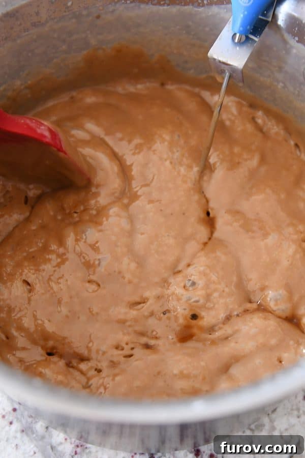 Vanilla extract being stirred into freshly cooked homemade caramels, infusing them with classic flavor.