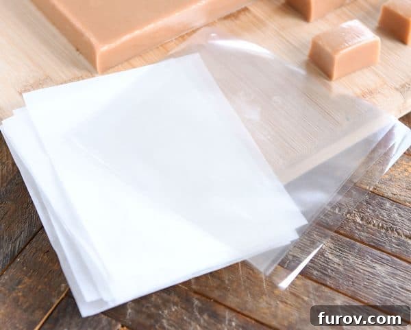 Homemade caramels being expertly cut and wrapped, transforming a slab into individual sweet treats.