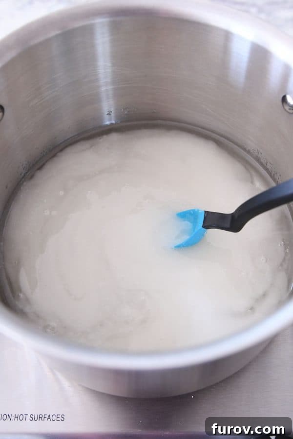 Sugar, corn syrup, and water being combined in a pot, the first step in making delicious caramels.