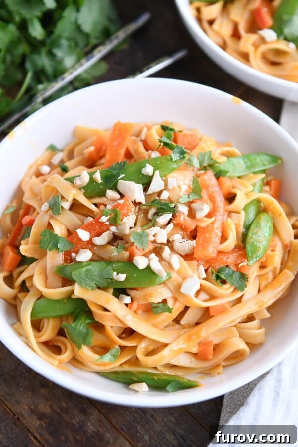 Deliciously Inauthentic Instant Pot Red Coconut Curry Noodles 2 Instant Pot red coconut curry noodles in white bowl with chopped peanuts.