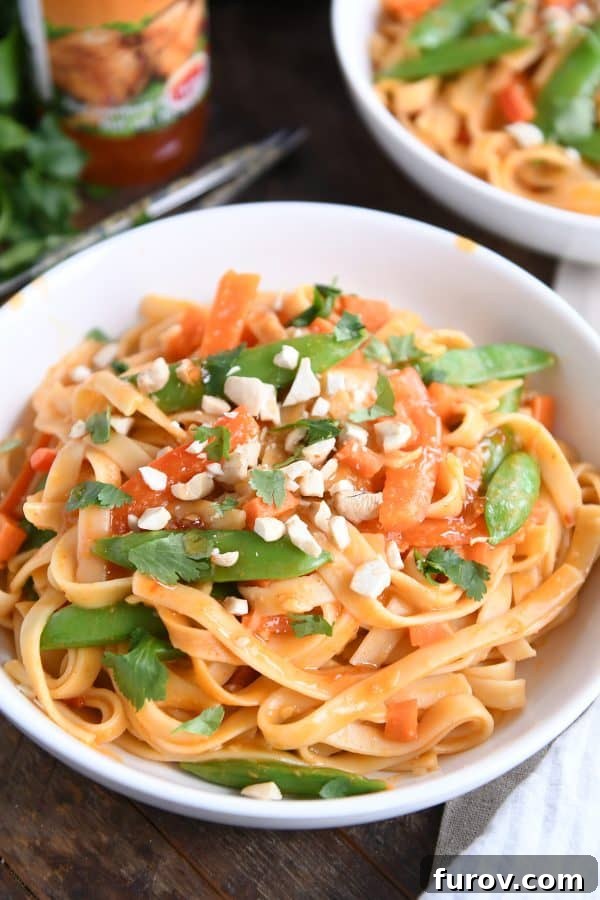 Deliciously Inauthentic Instant Pot Red Coconut Curry Noodles 10 Instant Pot red coconut curry noodles in white bowl with chopped peanuts.