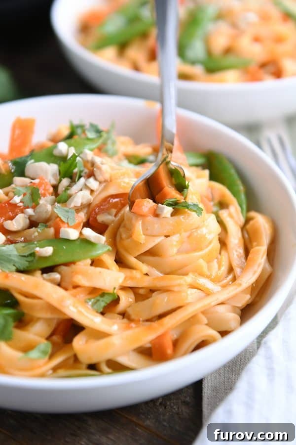 Deliciously Inauthentic Instant Pot Red Coconut Curry Noodles 3 Twirling instant pot red coconut curry noodles with fork in white bowl.