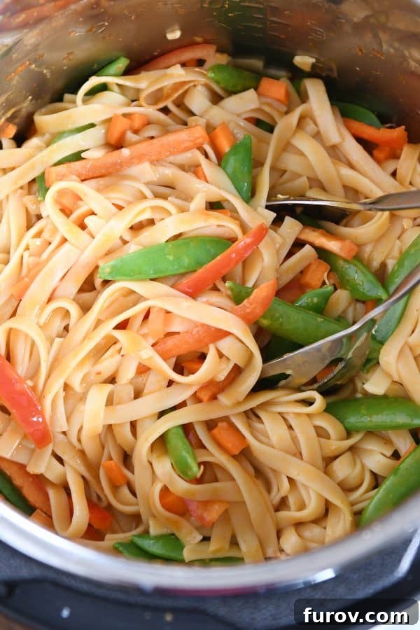 Deliciously Inauthentic Instant Pot Red Coconut Curry Noodles 8 Stirring noodles and veggies together in instant pot for red coconut curry noodles.