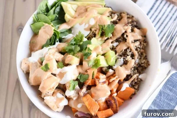 Top down view of a colorful Buddha bowl recipe with peanut sauce, fresh vegetables, and grains.
