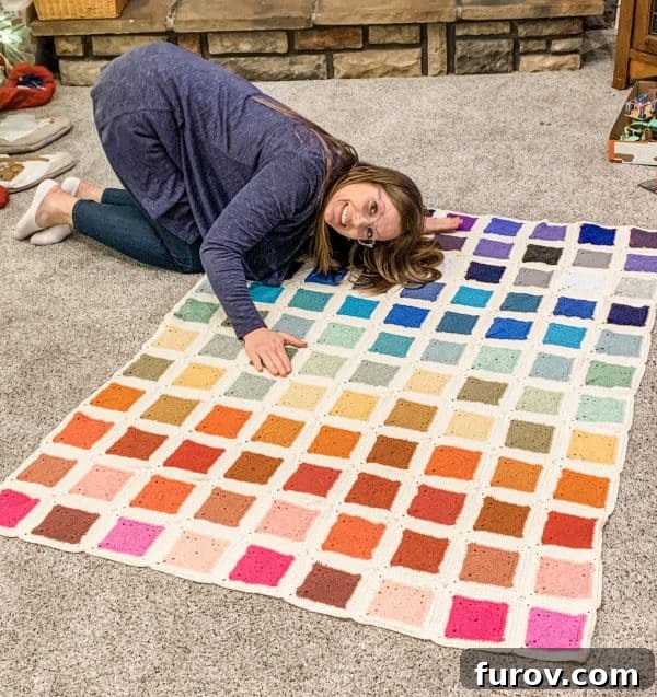 Beautifully finished rainbow crochet blanket laid out.