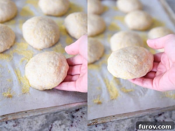 Simple Homemade English Muffins No Mixer Whole Grain 15 Picking up unbaked english muffins from baking tray.