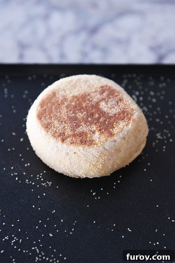 Simple Homemade English Muffins No Mixer Whole Grain 17 Golden brown homemade English muffin on a griddle.