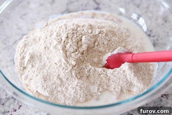 Simple Homemade English Muffins No Mixer Whole Grain 8 Stirring in dry ingredients to english muffin batter.