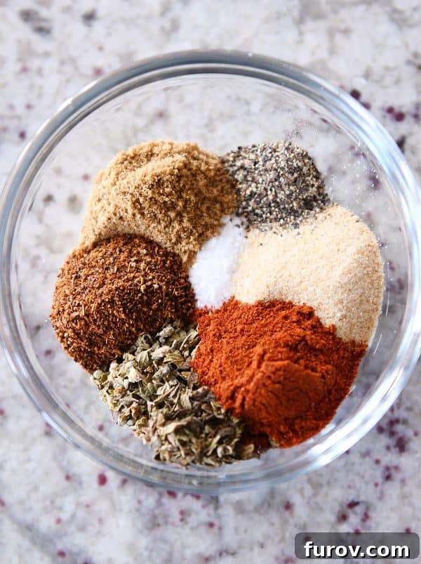 Ultimate Instant Pot BBQ Pork Tacos 4 A close-up shot of a small bowl filled with a homemade spice blend, featuring rich red paprika, ready to season the pork.