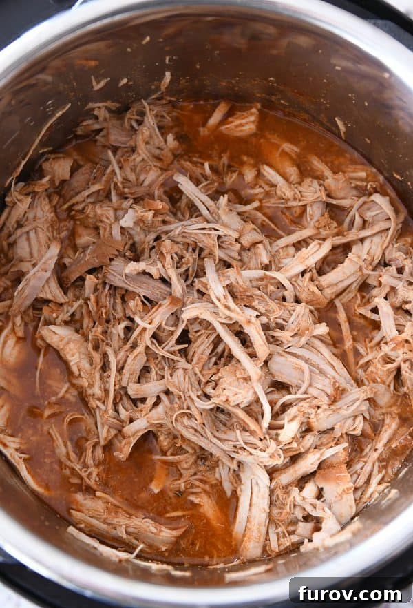 Ultimate Instant Pot BBQ Pork Tacos 7 A close-up of perfectly cooked and shredded pork, waiting to be mixed with additional seasonings and barbecue sauce.