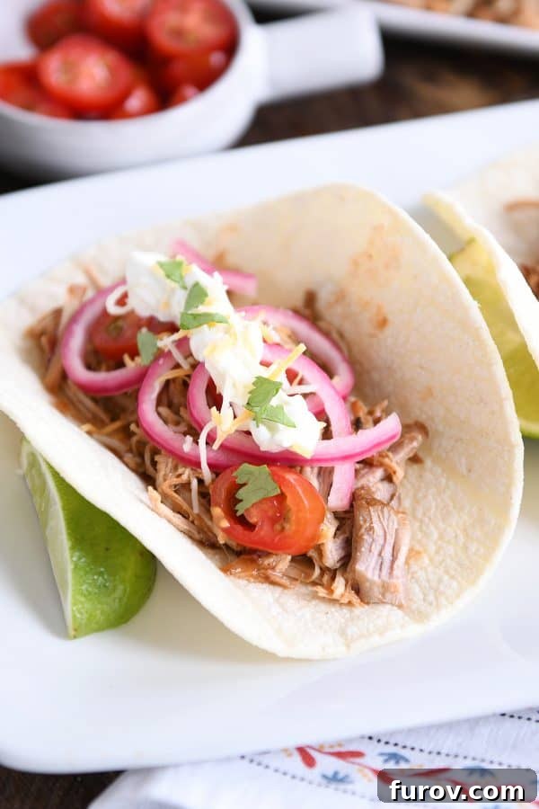 Ultimate Instant Pot BBQ Pork Tacos 8 A vibrant Instant Pot BBQ pork taco, beautifully topped with bright pickled onions, resting on a rustic wooden surface.