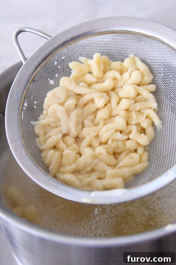 Whip Up Perfect German Spaetzle Quick Video Guide 10 Lifting out cooked spaetzle with strainer.