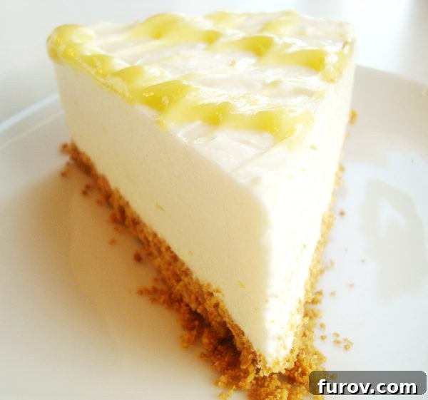 A perfectly sliced no-bake lemon cheesecake adorned with a delicate lemon curd drizzle, presented on a pristine white plate, invitingly ready for a summer indulgence.