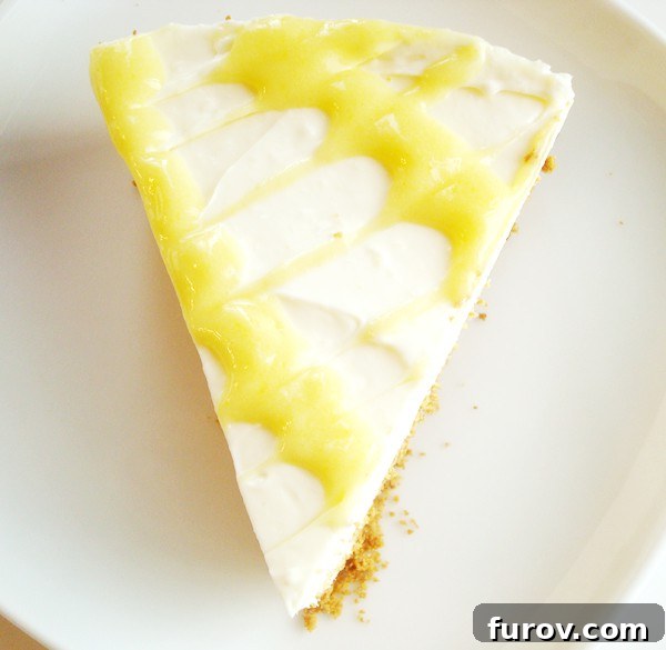 A stunning top-down view of a thick slice of lemon cheesecake, showcasing the artistic swirl of lemon curd on its surface.