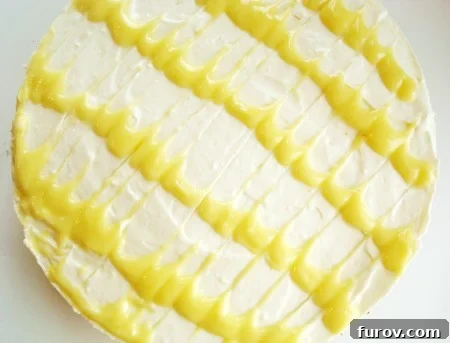A top-down view of the entire finished lemon cheesecake, showcasing its elegant marbled lemon curd topping.