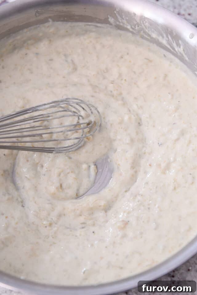 Stainless steel saucepan with cream sauce for enchiladas.