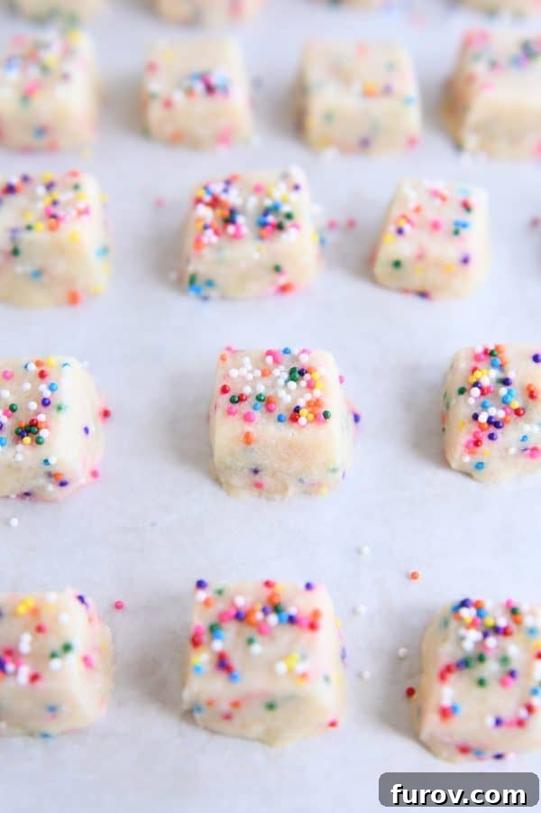 Baked funfetti shortbread bites perfectly arranged on a parchment-lined baking tray, ready to be enjoyed.