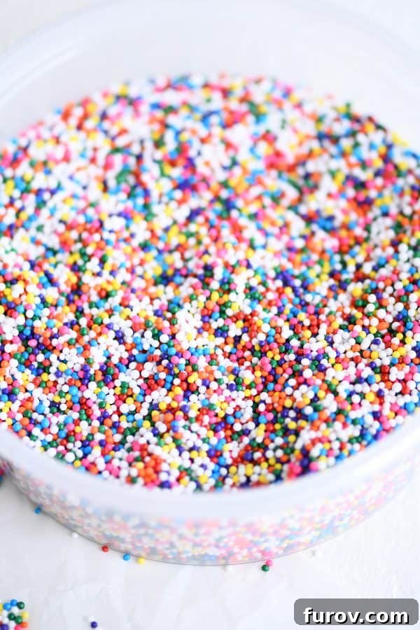 A small bowl overflowing with a colorful assortment of nonpareil sprinkles, ready to add cheer to any treat.