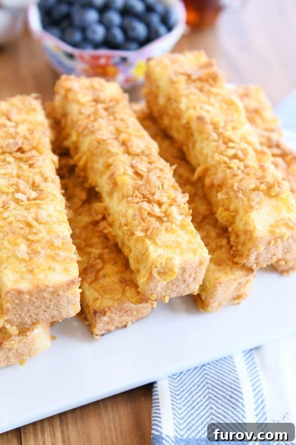 Crunchy baked french toast sticks on white platter.