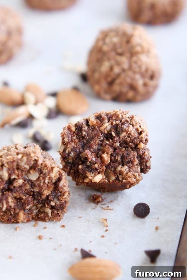 A chocolate peanut butter granola bite broken in half, revealing its fudgy, rich interior with mini chocolate chips.