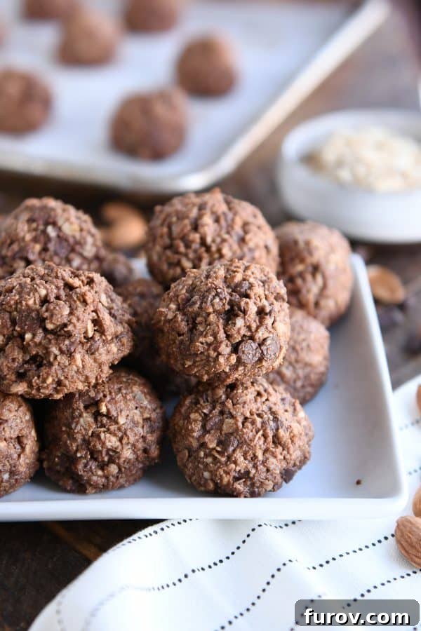 A collection of perfectly formed Chocolate Peanut Butter Granola Bites arranged neatly on a pristine white tray.