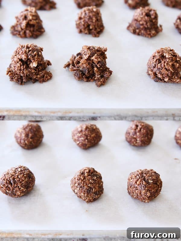 Hands rolling scooped portions of chocolate peanut butter granola mixture into perfectly round balls on a baking sheet, showcasing the easy shaping process.
