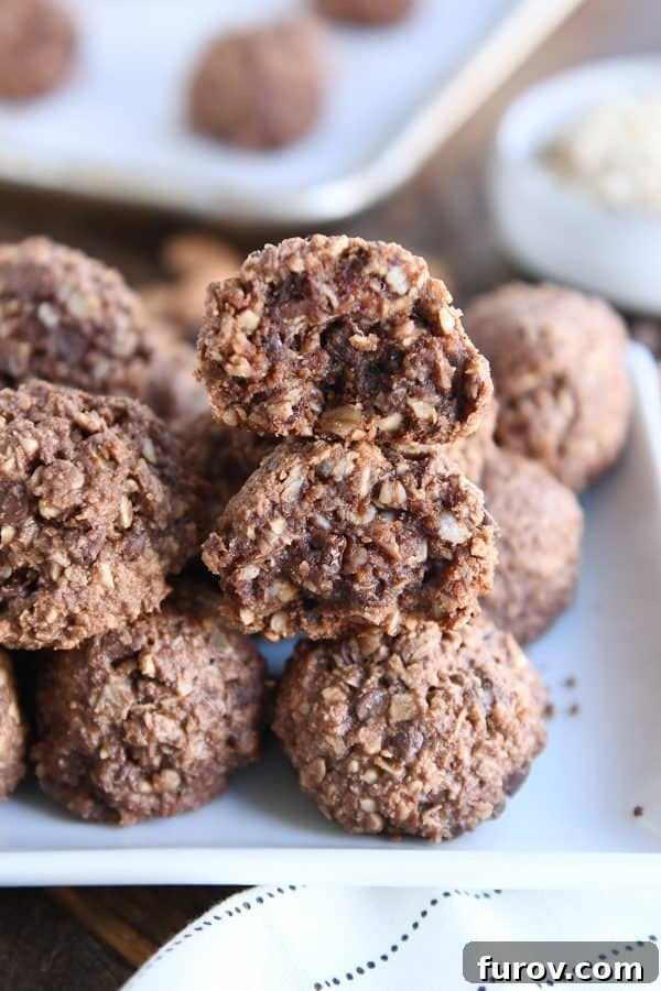 Beautifully stacked chocolate peanut butter granola bites arranged on a white tray, ready to be enjoyed as a perfect snack or dessert.